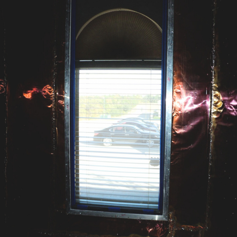 Arched top, shielded window with adjustable blinds, integrated into copper RF shielding.