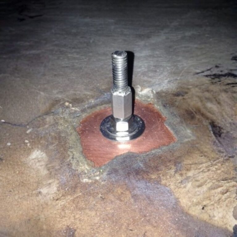 Close up of a non ferrous threaded grounding stud bonded to copper floor shielding.