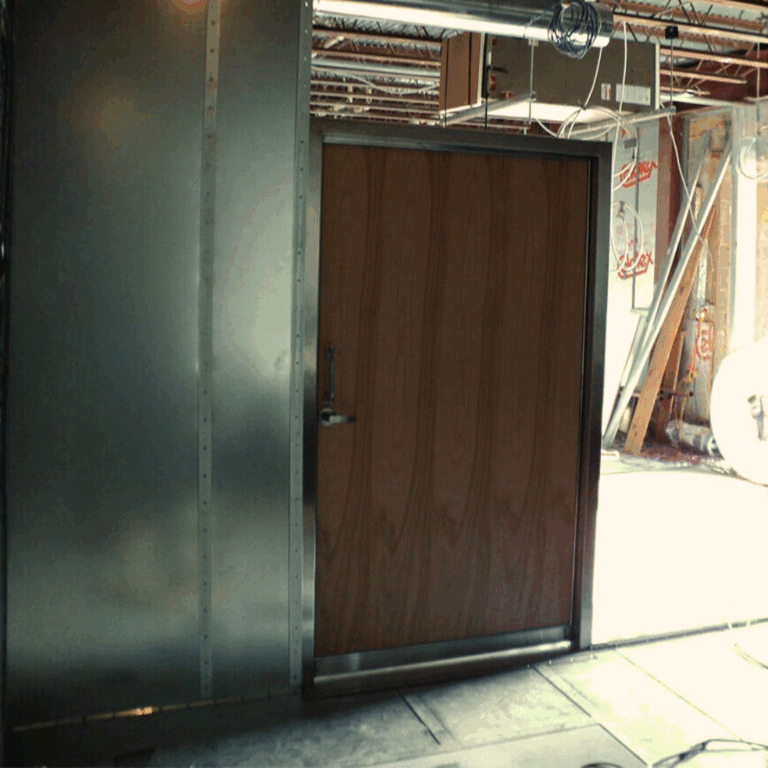 A custom wood veneer RF shielded door mounted in a steel frame ready for MRI room installation.