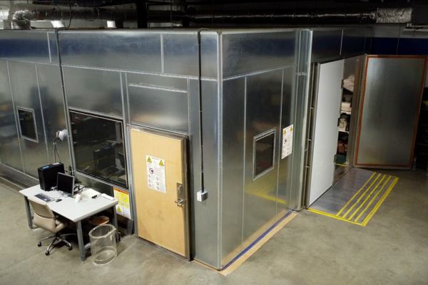 Completed, custom built radio frequency (RF) shielding enclosure with exterior control desk and sealed access doors in facility.