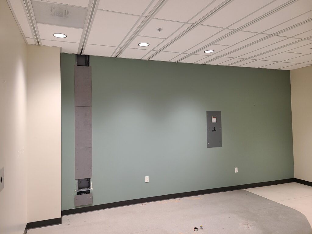 An empty medical imaging room with wall-mounted infrastructure visible after equipment removal.