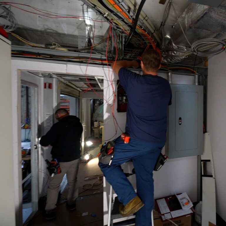MXR electricians installing power systems inside mobile imaging unit.