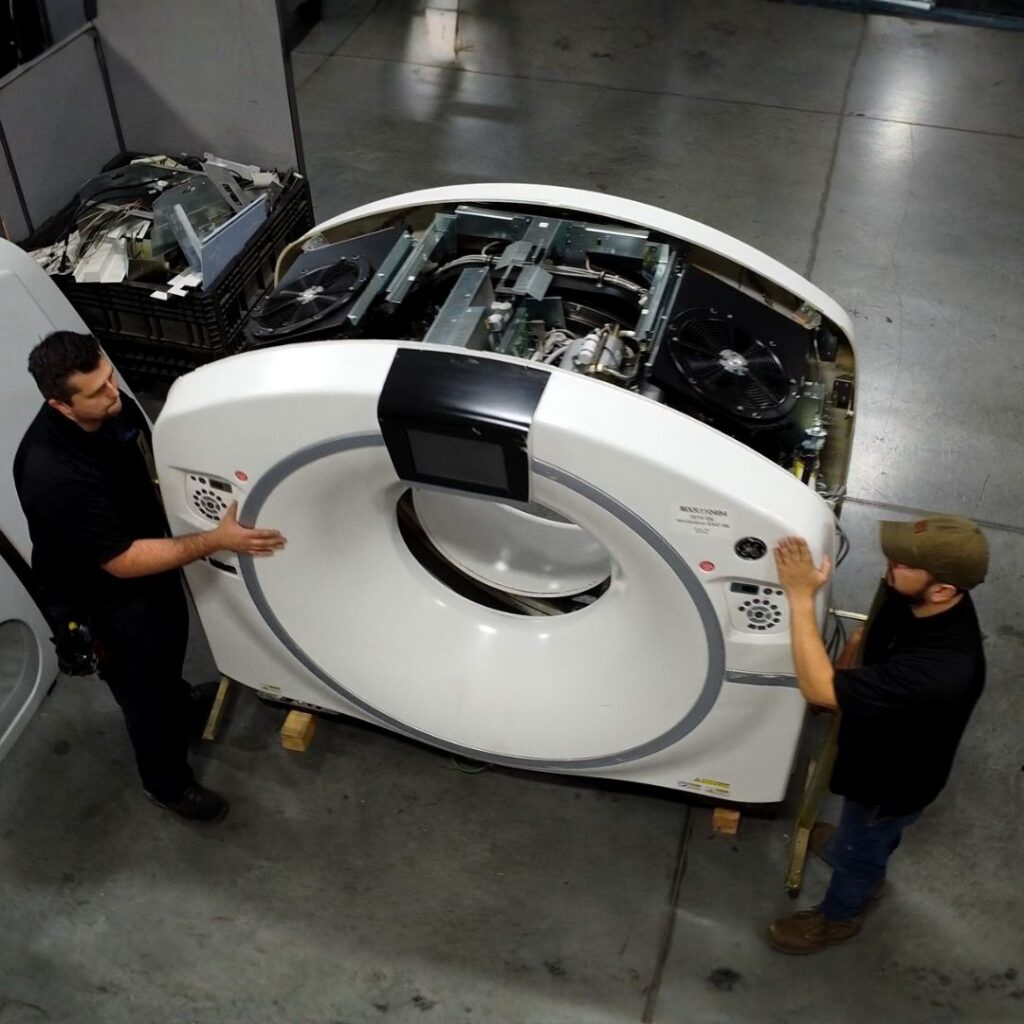 MXR Imaging engineers are relocating a CT scanner gantry within a warehouse facility.