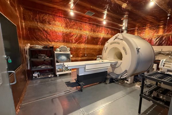 large MRI scanner machine is securely installed inside custom built room lined with bright copper radio frequency (RF) shielding.
