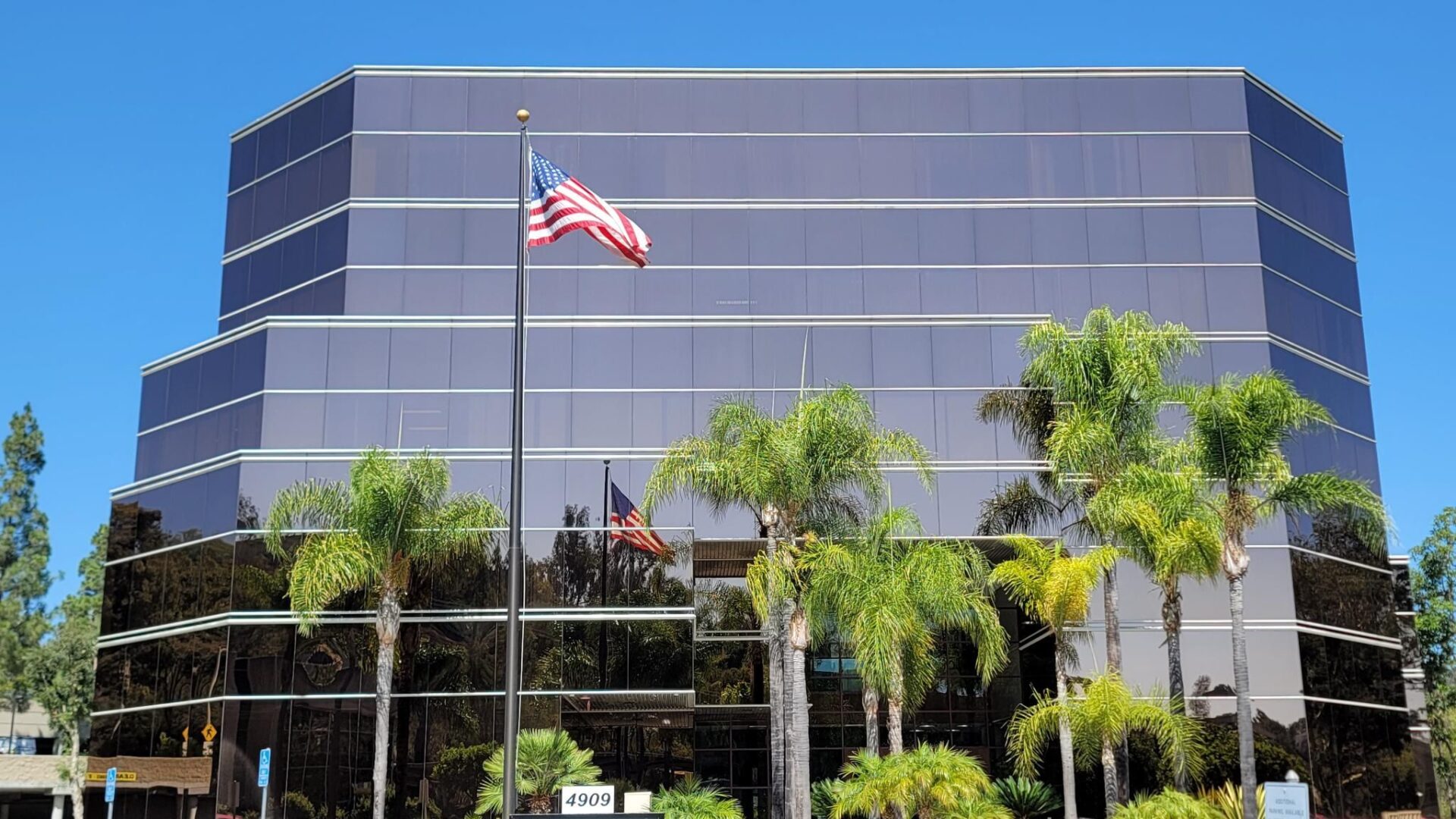 Exterior of the MXR Imaging corporate office, with prominent signage, palm tree landscaping, and blue sky.
