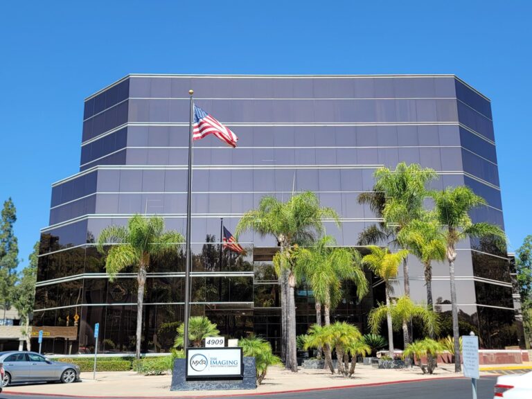 Exterior of the MXR Imaging corporate office, with prominent signage, palm tree landscaping, and blue sky.