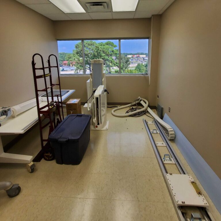 Disassembled X-ray floor rail components staged for transfer within the facility.