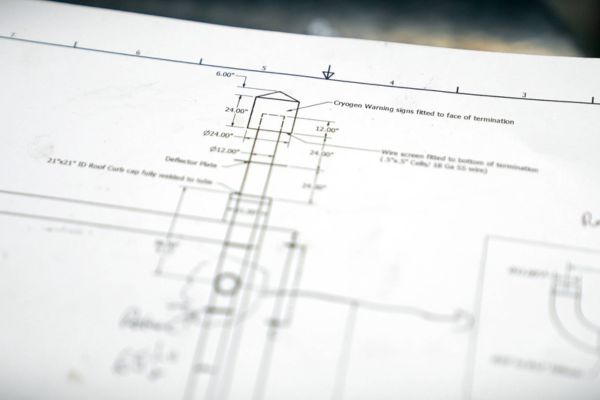 Close-up of engineering blueprints and design plans for a custom magnetic or radio frequency shielding enclosure project.