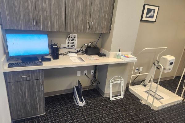 Professional podiatrist exam room with standing X ray equipment for foot and ankle imaging.
