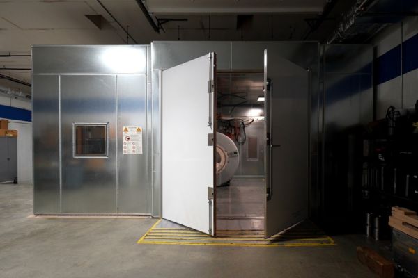 Custom built, galvanized sheet metal radio frequency (RF) MRI shielding room with its heavy, double magnetic doors standing open.