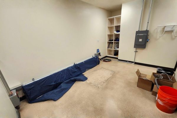 An empty medical imaging room with shelving and electrical panels visible after equipment removal
