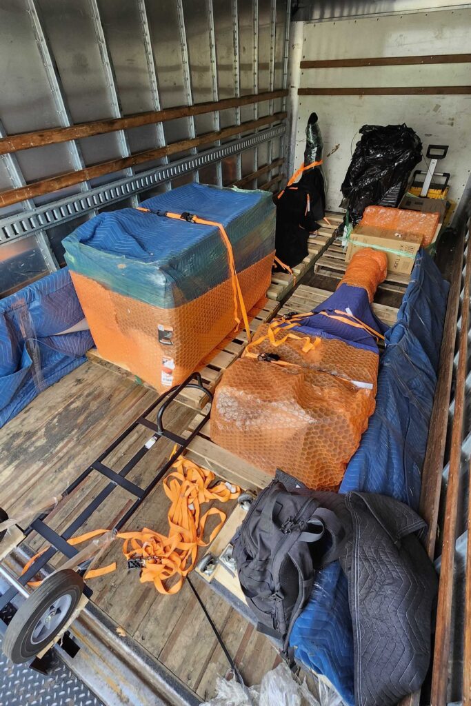 Securely strapped and padded medical imaging equipment inside a transport vehicle for a facility move.